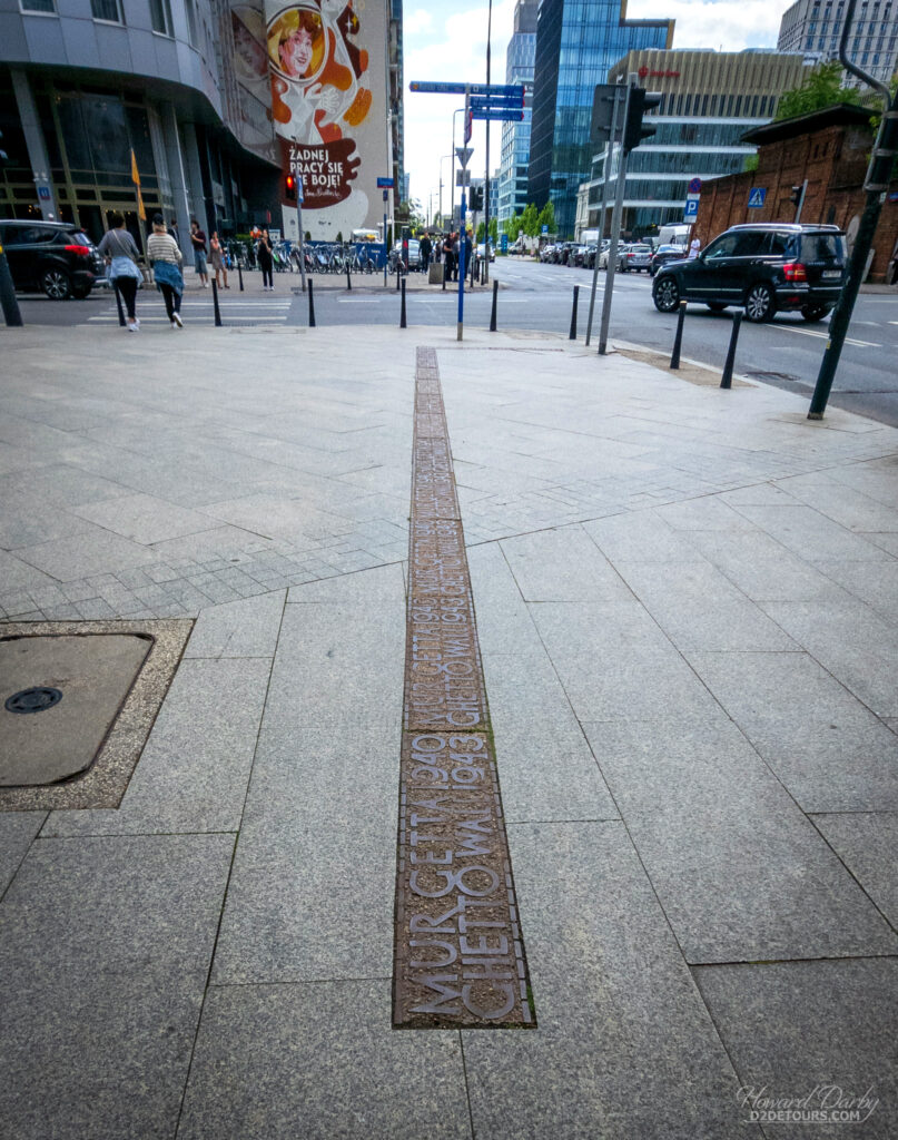 A wall was built around a large portion of Warsaw creating the Warsaw Ghetto, a prison for Jews before they either died or were eventually sent to eported to concentration camps. Parts of Warsaw have these lines built into the sidewalk as a reminder of where the ghetto walls existed.