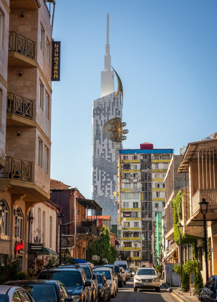 Looking down a street in old town Batumi towards the Batumi Tower that has a ferris wheel built into the side of it